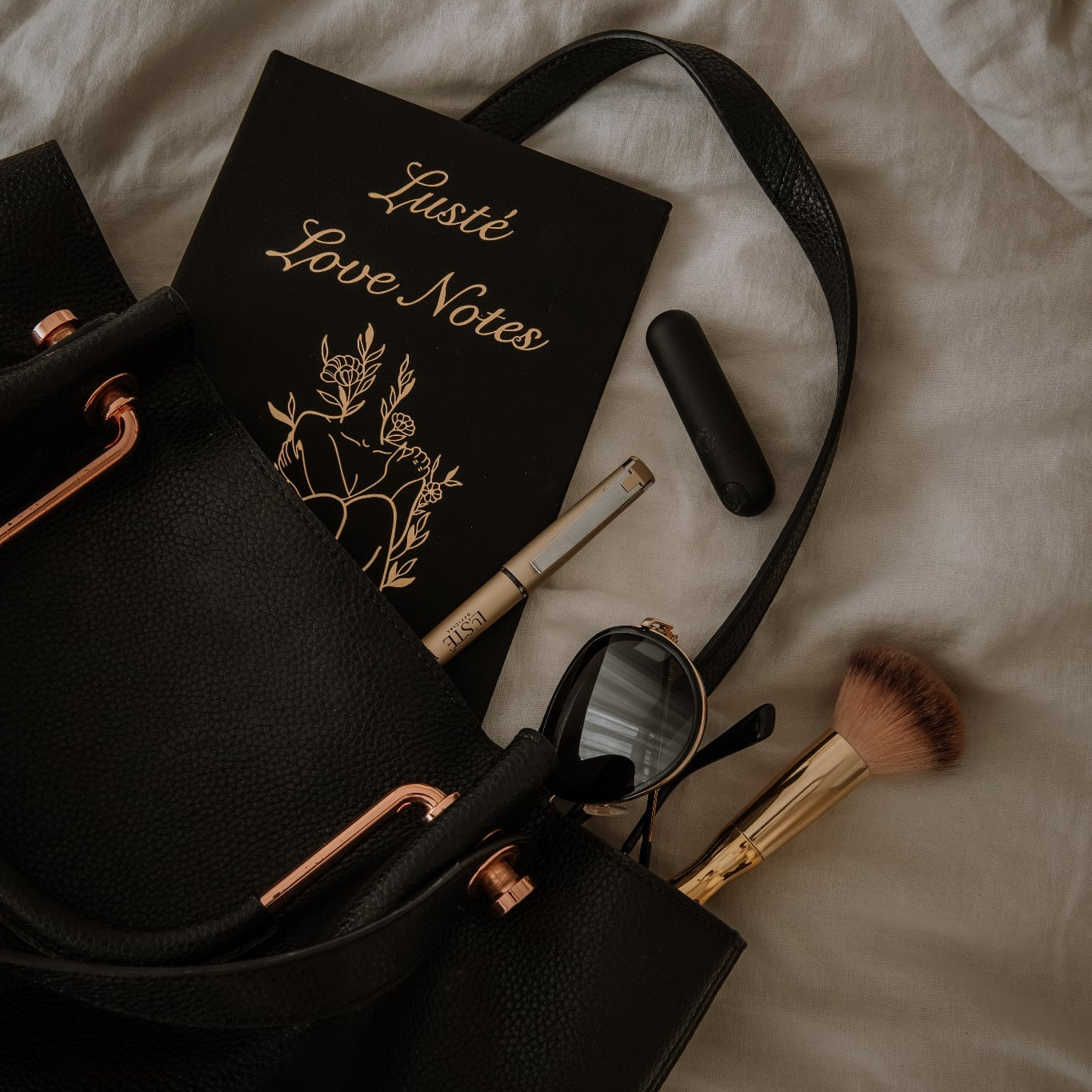 Lustè products falling out a black handbag