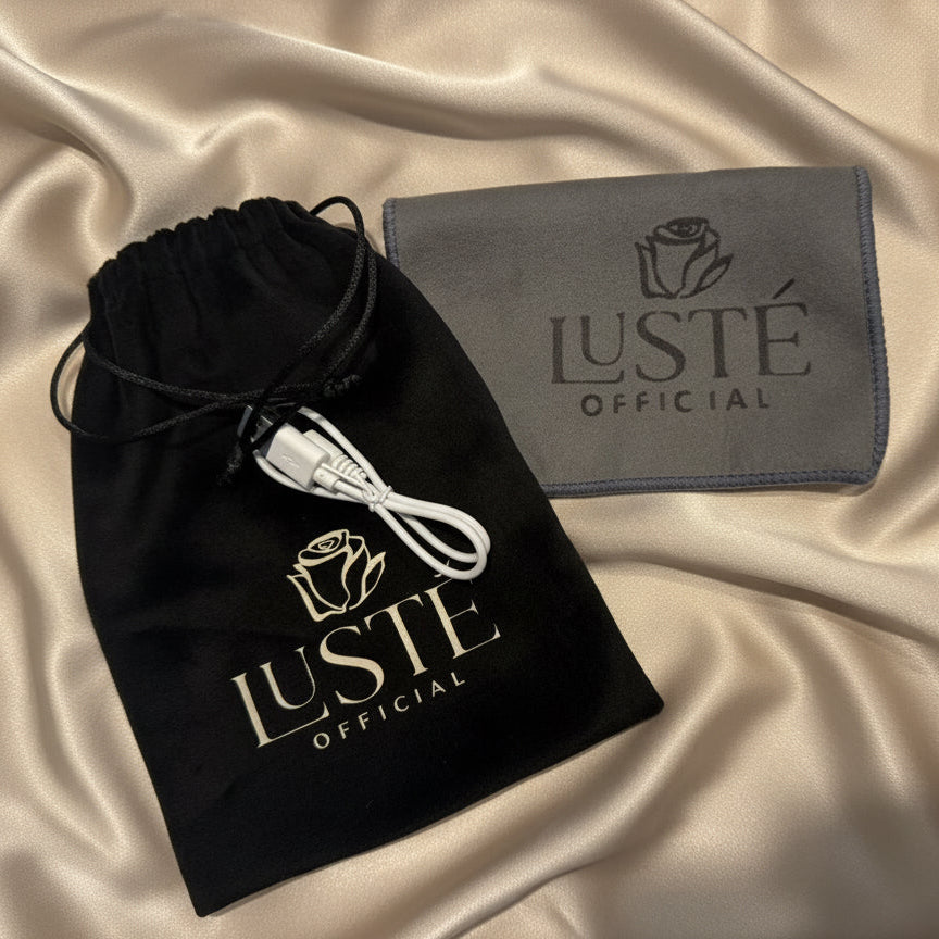 Luste branded charging cable, drawstring bag and cleaning cloth on beige satin