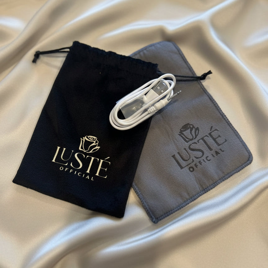 Lusté branded charger cable, cleaning clothing and keep bag on a satin surface