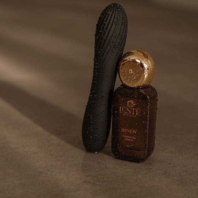 Black textured Reclaim Tool and Renew Tool cleaner spray in brown bottle with gold cap on a beige background